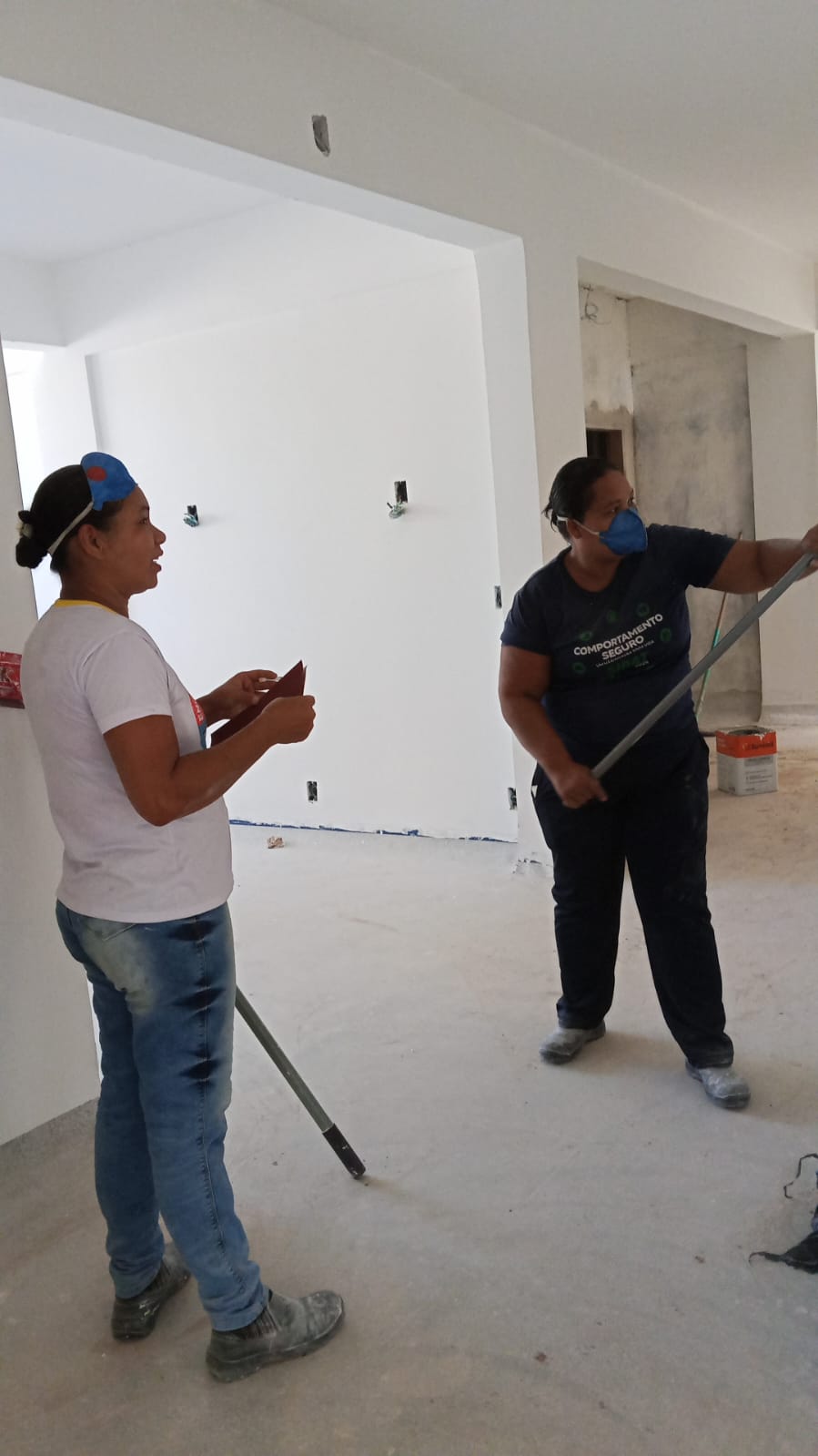 Equipe trabalhando em obra civil com paredes pintadas e parte elétrica